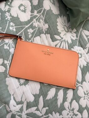 kate spade peach/orange leather wristlet with gold logo